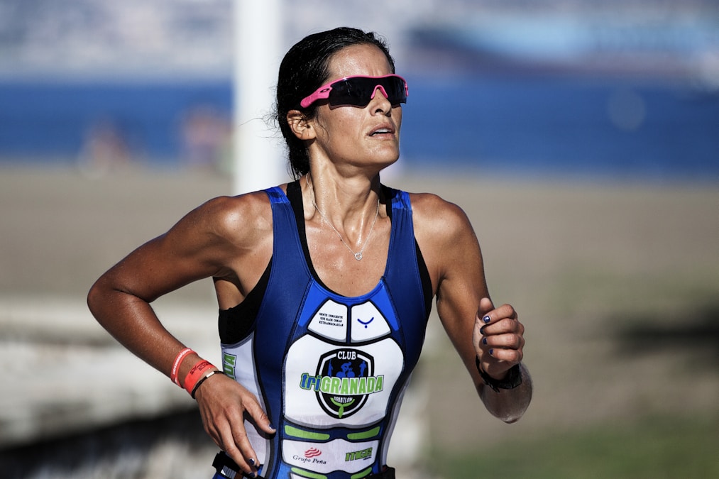 Selective-focus shot of a woman running outdoors with hair pulled back