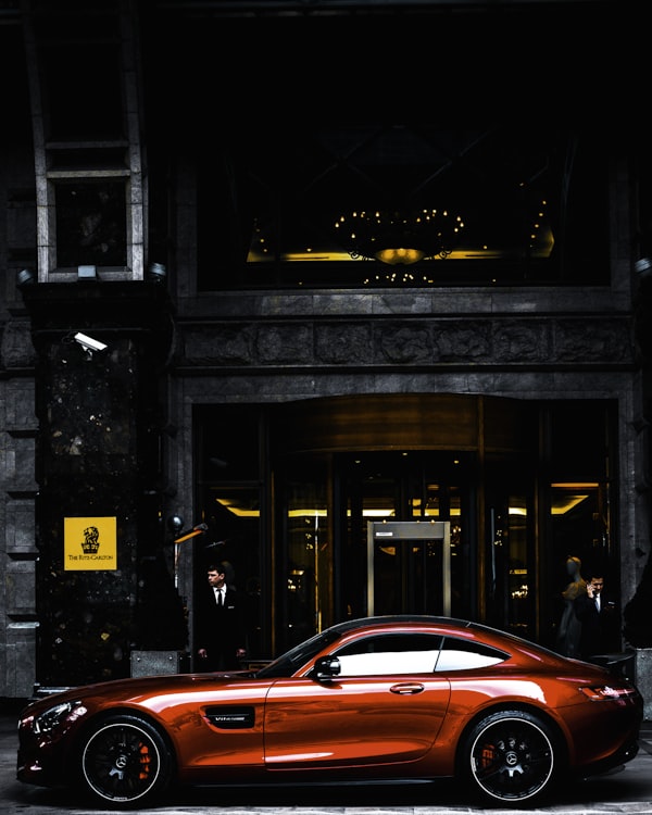 Executive coupe parked in front of a modern building