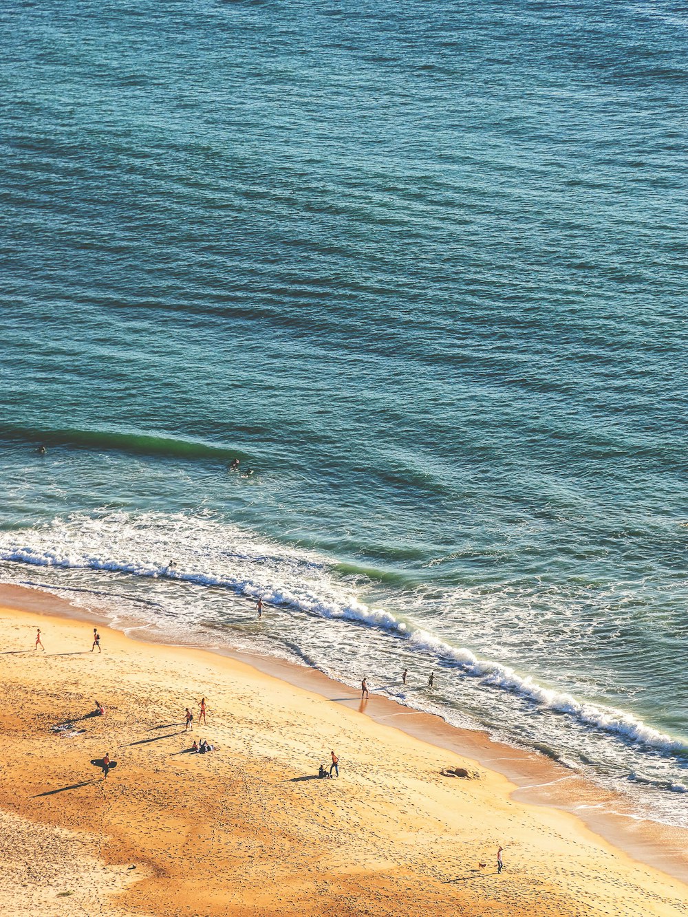 Gente de pie en la fotografía aérea de la orilla del mar