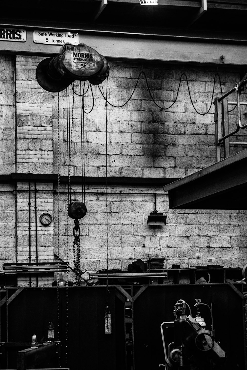 Photographie en niveaux de gris d’un mur avec des cordes et une machine