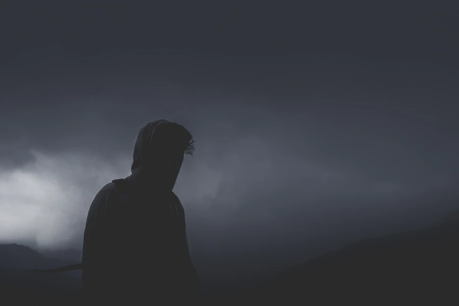 Fully dark hooded silhouette — placeholder portrait for Camille Ravon