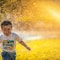 a young boy running through a sprinkle of water