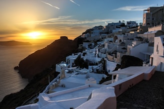 A vibrant sunset over the sparkling beaches of Cádiz with traditional white Andalusian houses in the background.