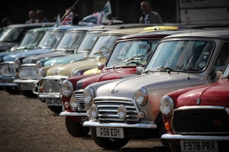 A selection of older models lined up outside a traditional UK service station, showing practical and dependable choices.