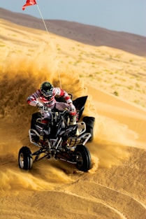 person riding on ATV and drift on sand