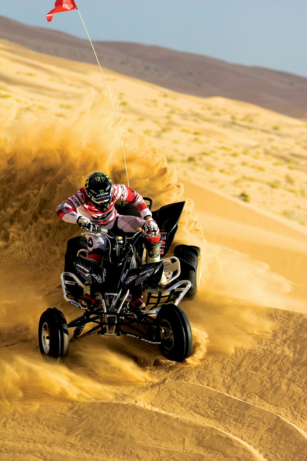 Person, die auf einem ATV fährt und auf Sand driftet