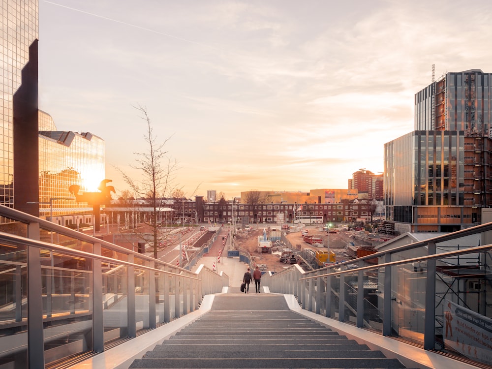 Fotografía de estructura arquitectónica de dos personas en escaleras cerca de edificios