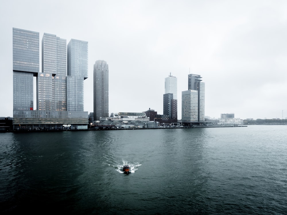 boat in the water with high-rise building in the background