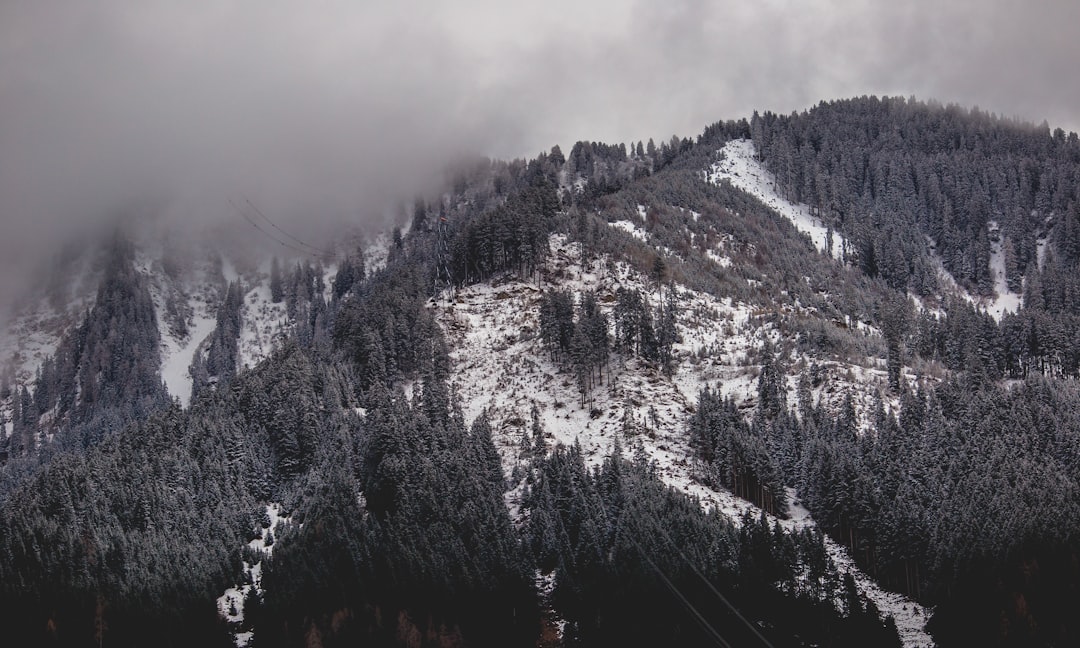 grayscale photography of snowy mountain covered by clouds