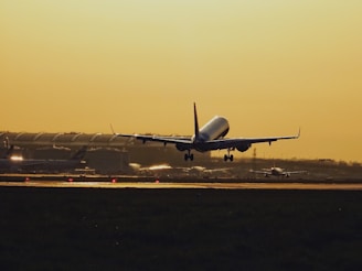 A cargo plane taking off from Dubai International Airport at sunset.
