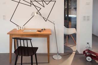 A cozy workspace with miniature car models and a laptop for online orders.