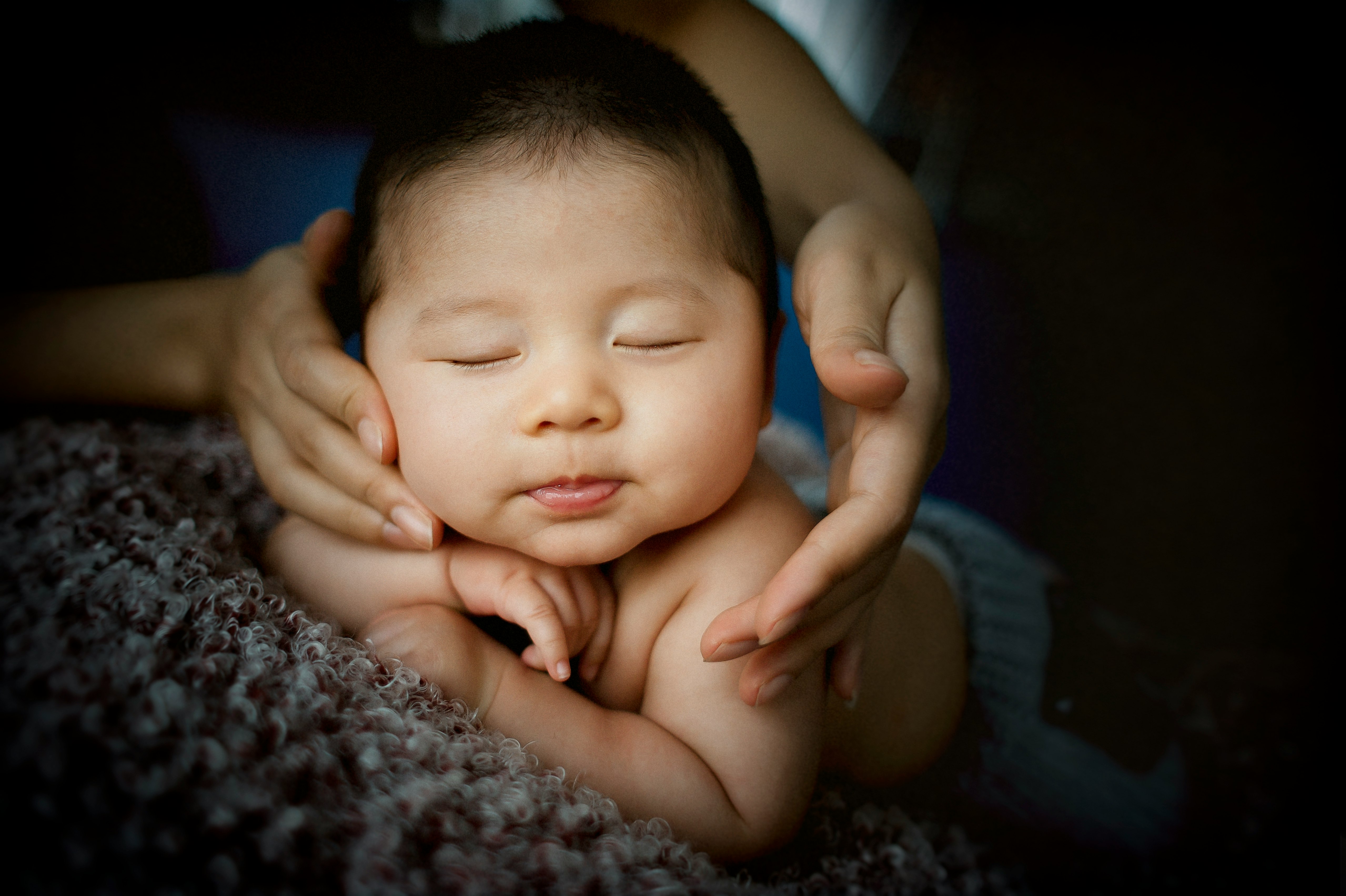 baby lying on gray textile