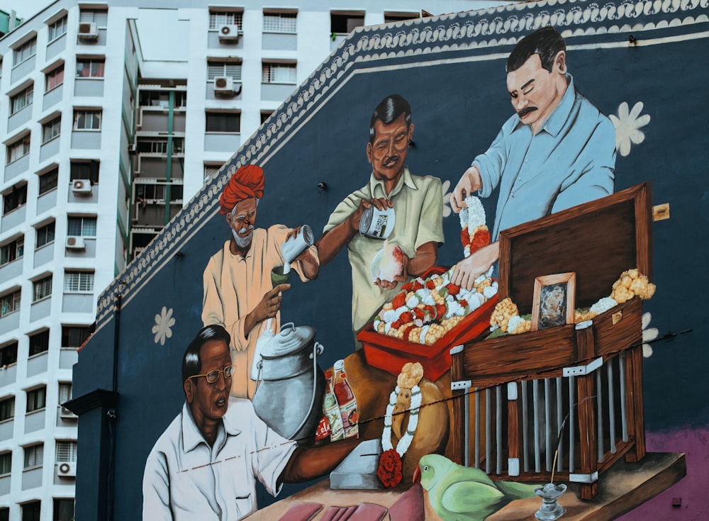 Cuatro hombres comiendo y bebiendo pintura mural cerca de un edificio alto durante el día