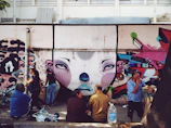 Students gathered around a colorful mural they painted