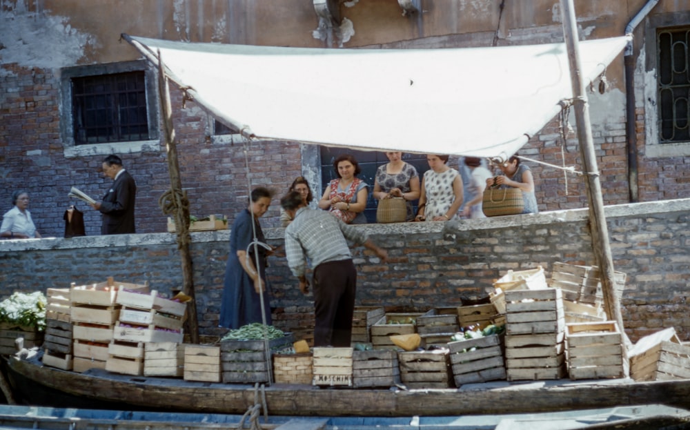 Mann und Frau auf dem Boot verkaufen Früchte in Kisten