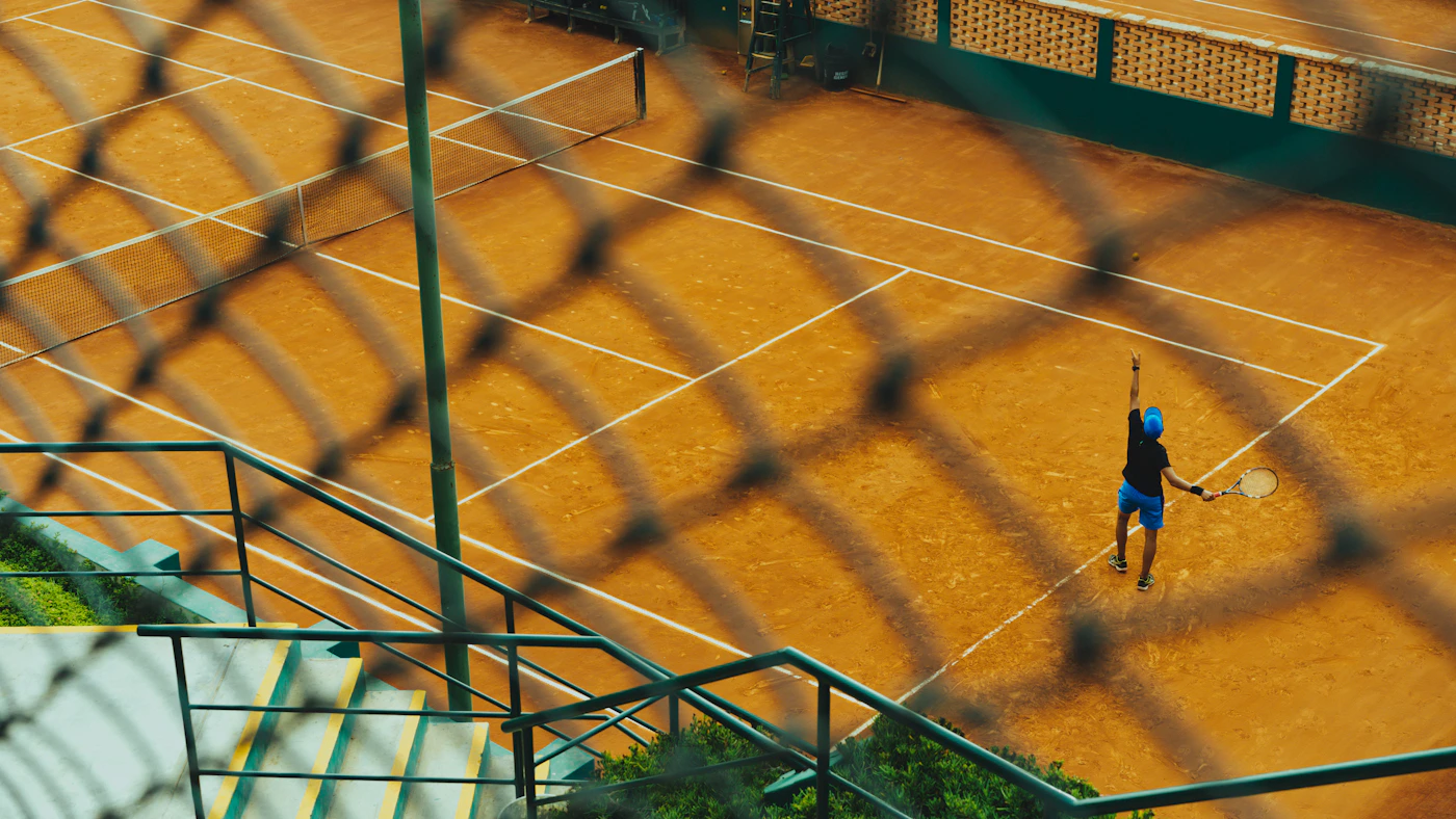 Tennis player serving on a clay court