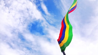 red, blue, yellow, and green striped flag under blue sky