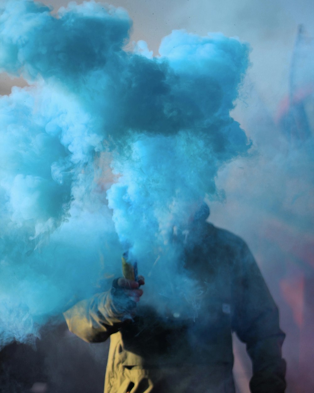 person holding stick with blue smoke photo Free Blue person holding stick with blue smoke photo Free Blue