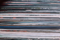 A stack of classic 33 RPM vinyl records in colorful sleeves.