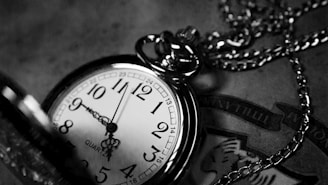 grayscale photography of analog pocket watch