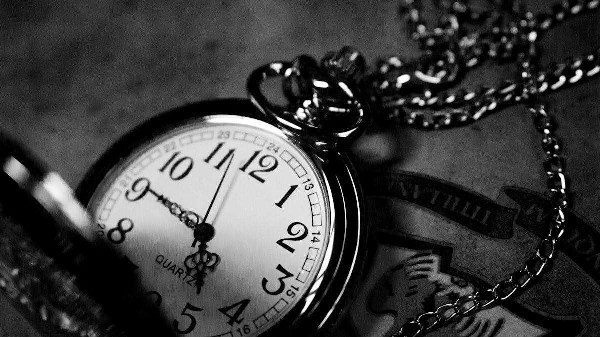 Black and white photo of a pocketwatch with a chain.