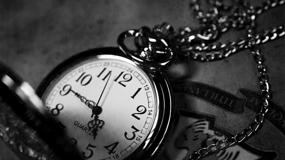 grayscale photography of analog pocket watch