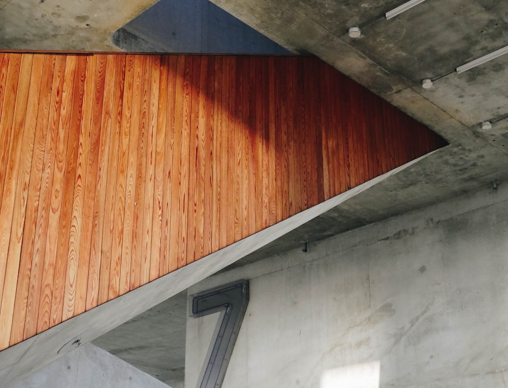 Pannellatura in legno sul lato di una scala in un edificio con pareti in cemento a vista