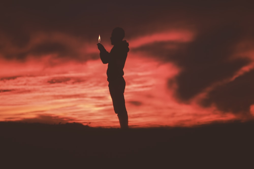 silhouette of man holding lighter