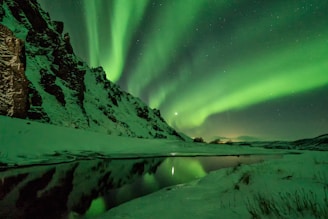 snow covered mountain with aurora borealis