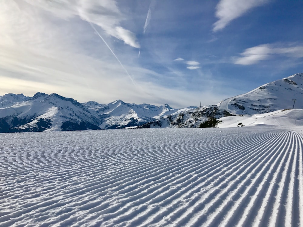 Terreno innevato, vicino alle montagne durante il giorno