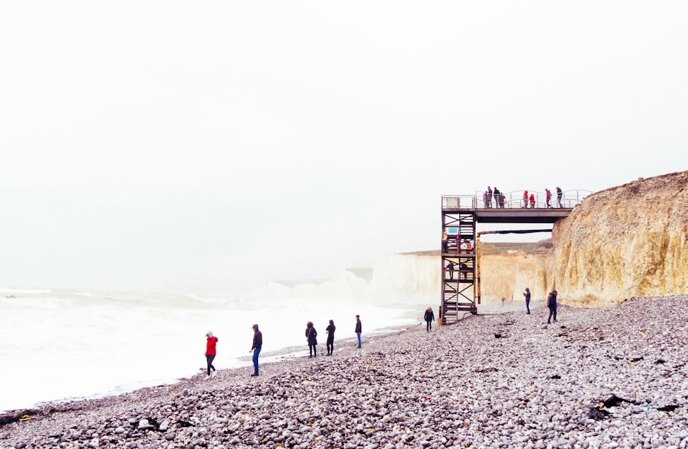 Un gruppo di persone in piedi sulla cima di una spiaggia rocciosa