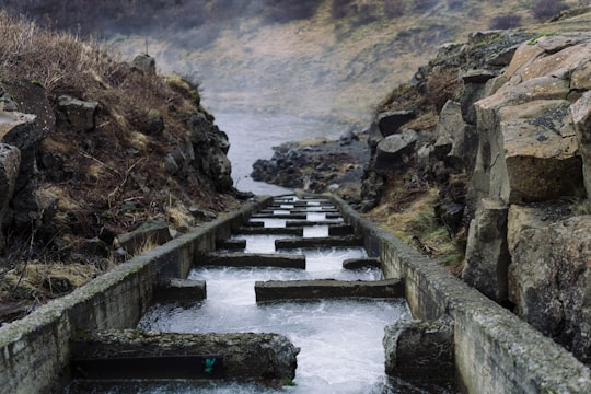 water dam between gray rock formation in Faxi Iceland