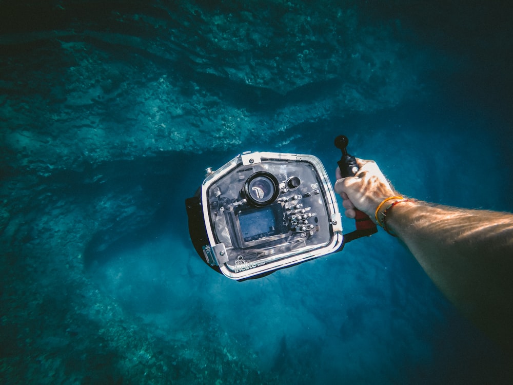 person holding underwater camera