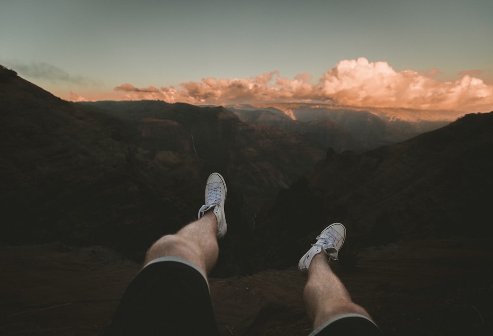 person sitting white facing cliff