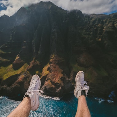 person above mountain and body of water