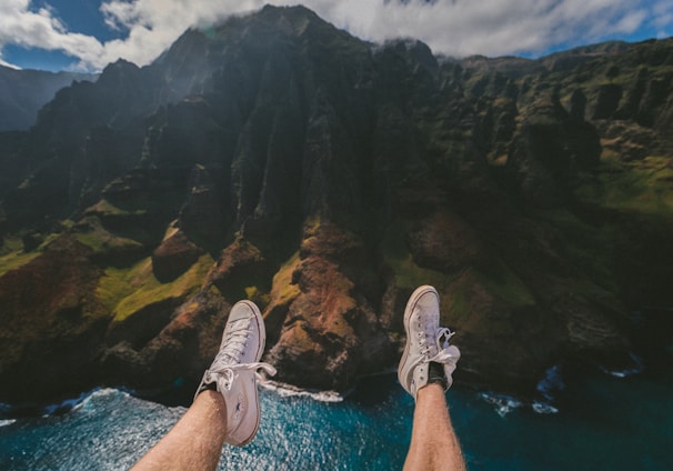 person above mountain and body of water