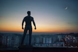 silhouette photography standing on peak front of high-rise buildings