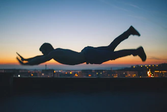 Illustration of Keluang Man soaring over Kuala Lumpur’s skyline at dusk.
