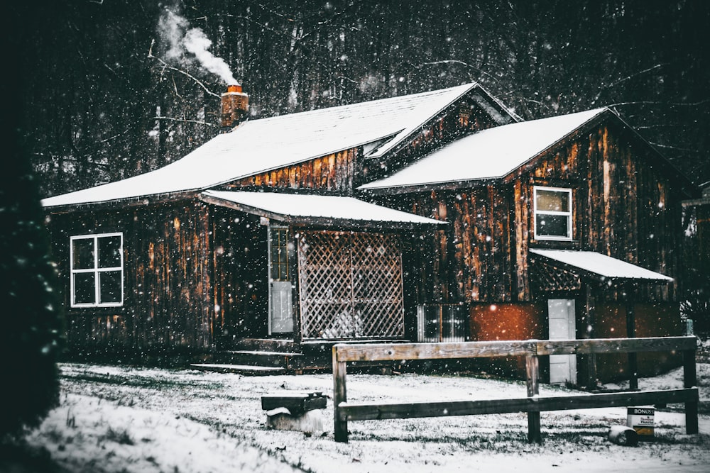 雪に覆われた茶色い木造家屋