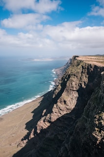 brown cliff beside ocean