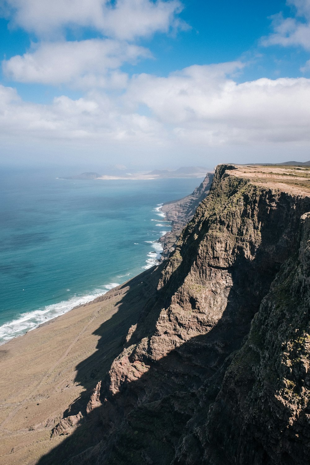 brown cliff beside ocean