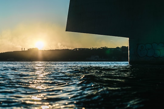 low angle photography of sun behind building on hill over the sea in Cherepovets Russia