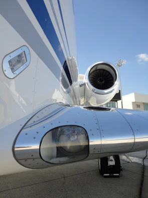 Close-up of a jet engine with intricate details shining under bright hangar lights.