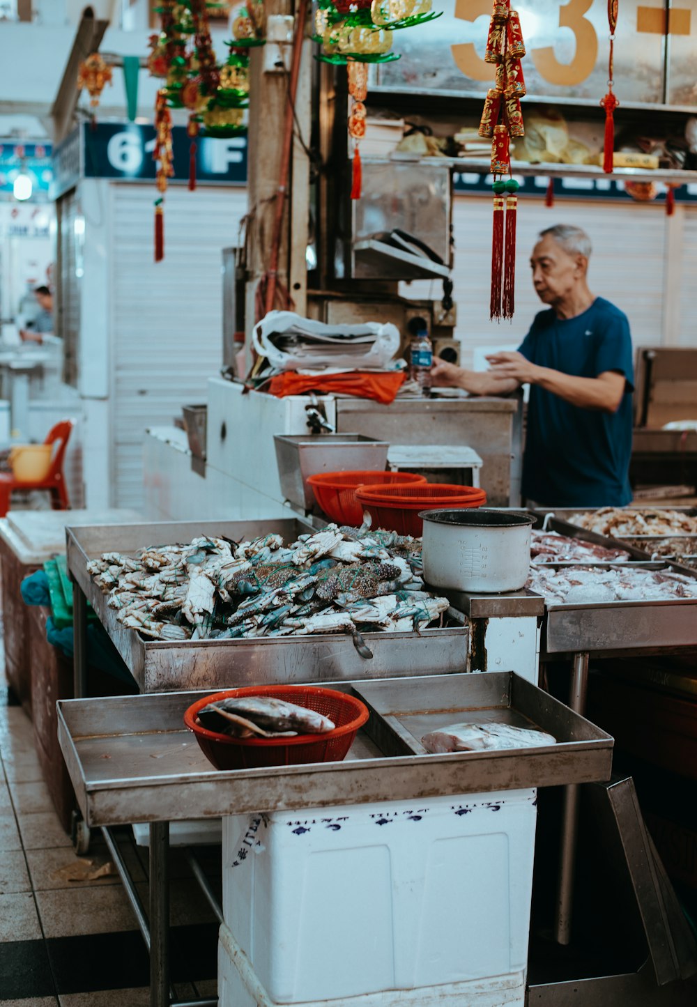 man filling clear plastic bottle near storefront