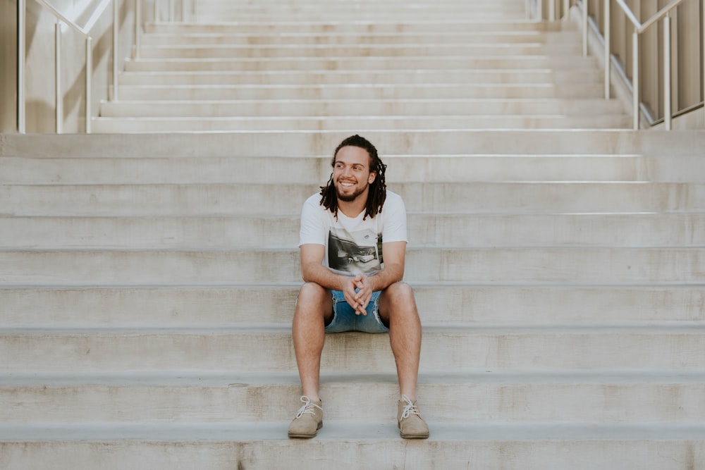 homem sorridente sentado na escada