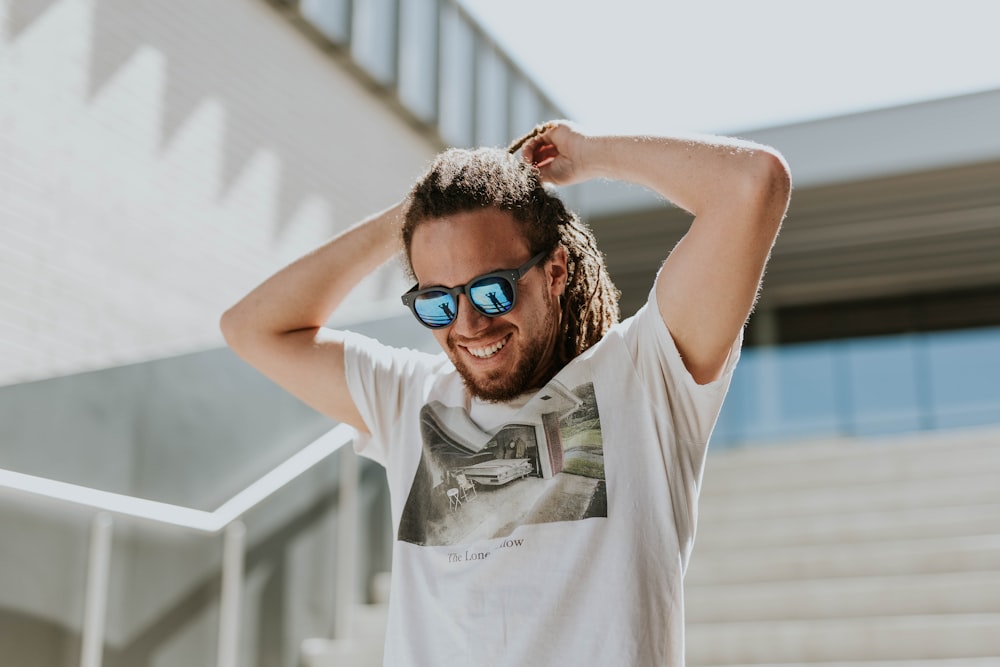 Mann bindet sich die Haare zusammen, während er auf der Treppe geht