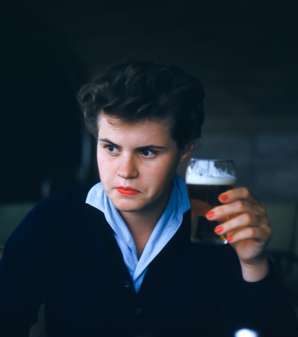 hombre sentado mientras sostiene un vaso de cerveza