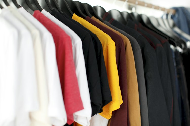 Folded printed t-shirts and mugs laid out for quality inspection before shipping
