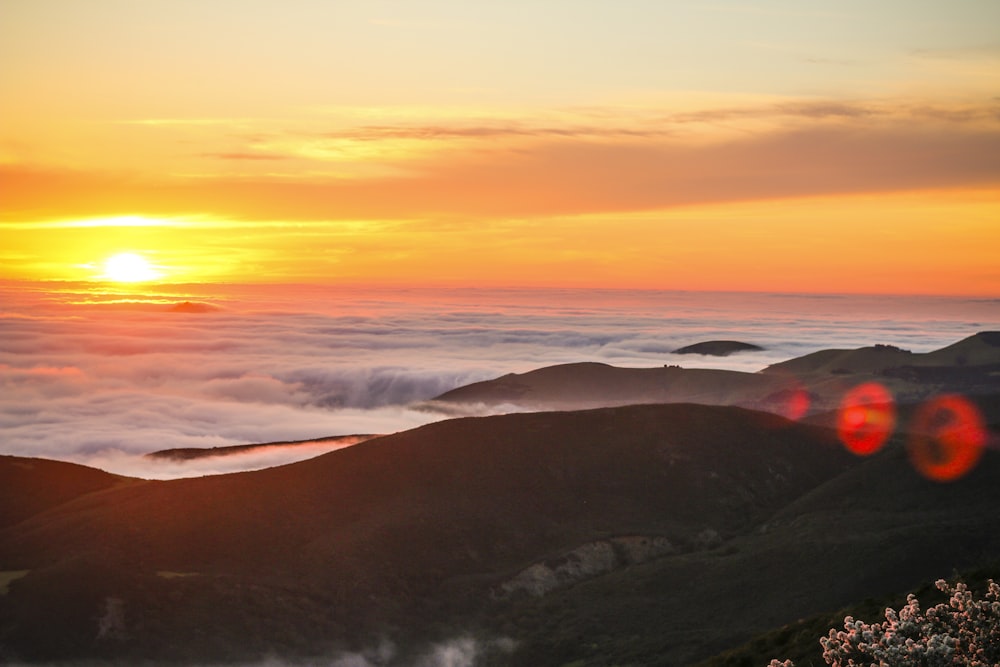 sun over the clouds and hill