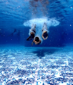 three person diving on water